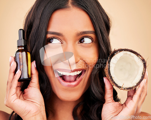 Image of Happy woman, hair and beauty, coconut oil product with natural treatment and cosmetic care on studio background. Haircare, eco friendly and vegan with fruit, serum and shampoo with bottle and shine