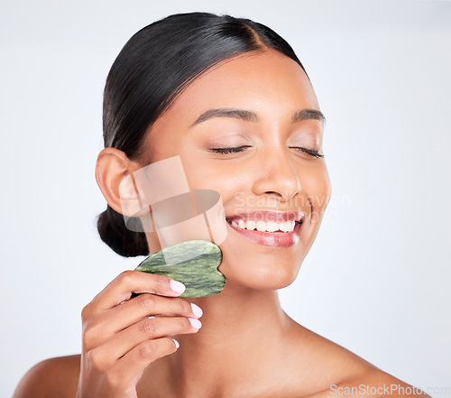 Image of Woman, face and gua sha, beauty and tools with jade stone for natural skincare isolated on white background. Facial massage, facelift and grooming with skin glow, dermatology and wellness in studio