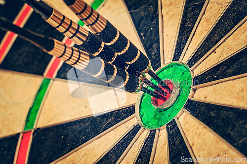 Image of Three darts in bull's eye close up