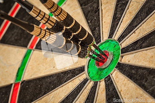 Image of Three darts in bull's eye close up