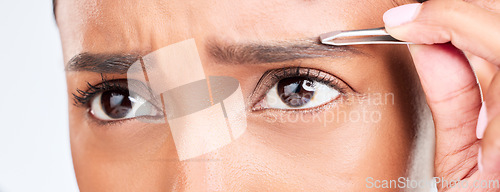 Image of Eyes, pain and woman with tweezers for eyebrow in studio, tools for self care and grooming. Facial hair removal, dermatology and beauty skincare, face of model on white background for clean skin glow