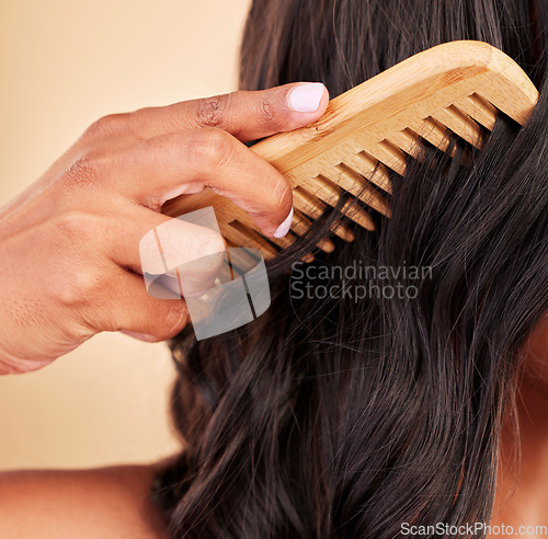 Image of Comb, hair care and closeup of woman in studio with clean salon treatment hairstyle for wellness. Beauty, cosmetic and zoom of female model with tool for haircut maintenance by a brown background.