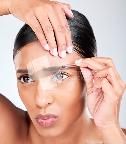 Image of Hair removal, pain and woman with tweezers in studio, tools for self care and skincare grooming. Facial, dermatology and eyebrow maintenance, face of model on white background for clean skin glow.