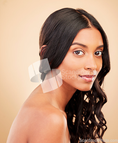 Image of Hair care, beauty and face of woman in studio isolated on a brown background. Curly hairstyle, natural cosmetics and portrait of Indian model in salon treatment for health, wellness or skin aesthetic