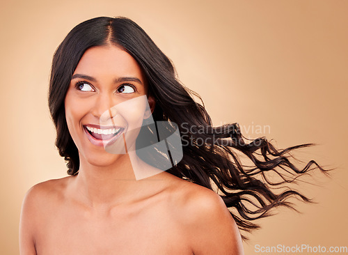 Image of Thinking, hair care and happy woman with wind growth or beauty isolated in a studio brown background with strong texture. Aesthetic, natural and young person with cosmetics for health and shine