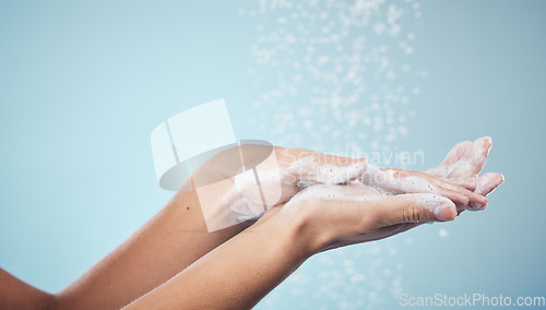 Image of Cleaning, hands and woman with soap and water in studio, blue background and healthcare or skincare mockup. Model, closeup or washing skin for clean, hygiene and protection from bacteria or virus