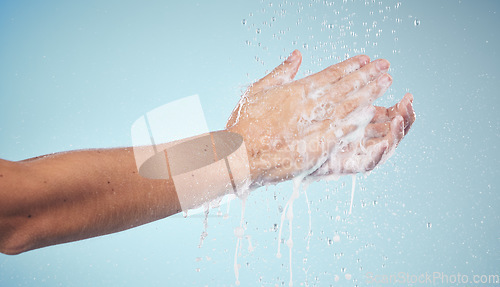 Image of Hands, cleaning and woman with soap and water in studio, blue background and healthcare mockup or skincare. Model, closeup or washing skin for clean, hygiene and protection from bacteria or virus