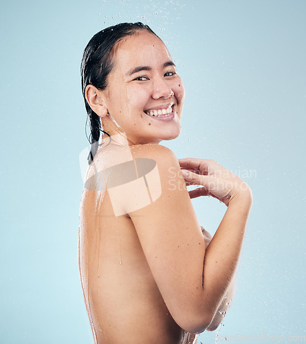 Image of Shower, portrait or happy woman cleaning body for wellness or dermatology in studio on blue background. Smile, beauty or wet girl washing or grooming for healthy natural hygiene or skincare to relax