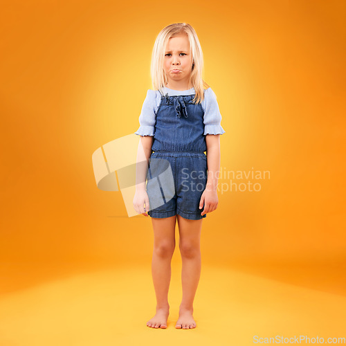 Image of Portrait, sad and girl child in studio with bad news, feedback or negative review on orange background. Face, frown and kid with emoji disappointed expression, angry or tantrum, reaction or behavior