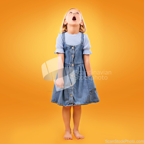 Image of Fashion, wow and girl child in studio for news, omg or coming soon promotion on orange background. Looking up, surprise and kid shocked by choice, sale or discount, announcement or prize giveaway