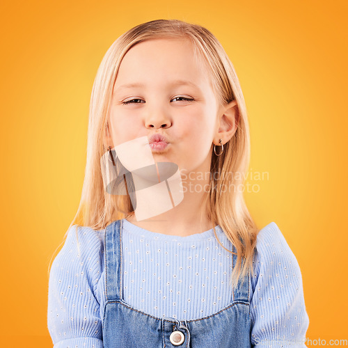 Image of Happy, pout and portrait of girl on orange background with happiness, joy and excited in studio. Confidence, childhood and face of young, adorable and cute child with kiss emoji facial expression