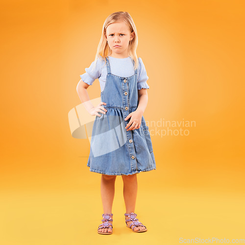 Image of Angry, sad and portrait of girl child in studio with bad news, feedback or negative, review or vote on orange background. Face, frown and annoyed kid with emoji tantrum, behavior or attitude problem