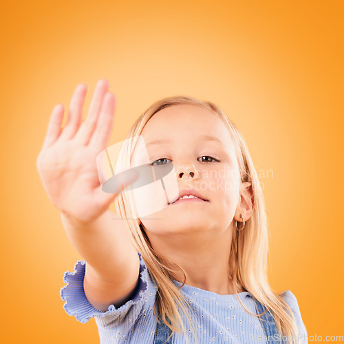 Image of Stop, hand and portrait of girl child in studio with no, warning or vote on orange background space. Protest, palm and face of kid with emoji for control, power or voice, opinion or limit choice