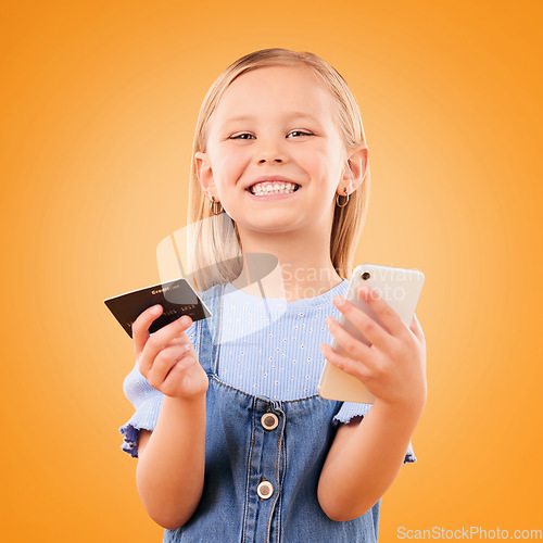 Image of Portrait, child and credit card with phone in studio for online shopping order, digital payment and fintech on orange background. Happy girl kid, smartphone and buy mobile games, sales and savings