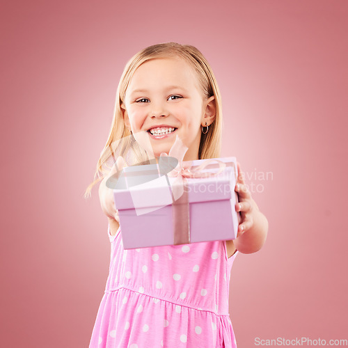 Image of Studio, giving present portrait of a child for birthday, holiday or happy celebration. Excited girl kid on a pink background with ribbon on gift box for surprise, giveaway prize or celebrate kindness