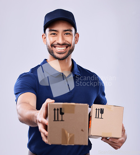 Image of Smile, portrait and delivery man giving boxes in studio, safe transport for ecommerce supplier product. Package, logistics and happy courier person on white background for online sales and services.