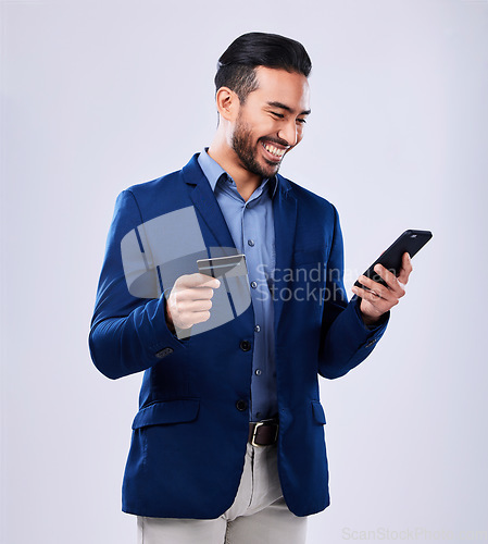 Image of Credit card, phone and a business man in studio for online shopping, fintech payment or website. Asian person with a smartphone and finance for savings, e commerce or banking on a grey background