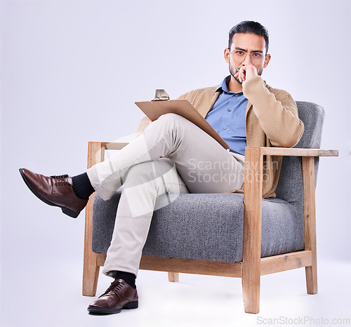 Image of Portrait, serious and a man psychologist in a chair on a white background in studio to listen for diagnosis. Psychology, mental health and concern with a person counseling during a therapy session