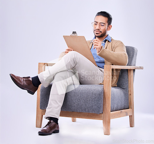 Image of Documents, diagnosis and a man psychologist in a chair on a white background in studio to listen for diagnosis. Psychology, mental health and trauma with a person counseling during a therapy session