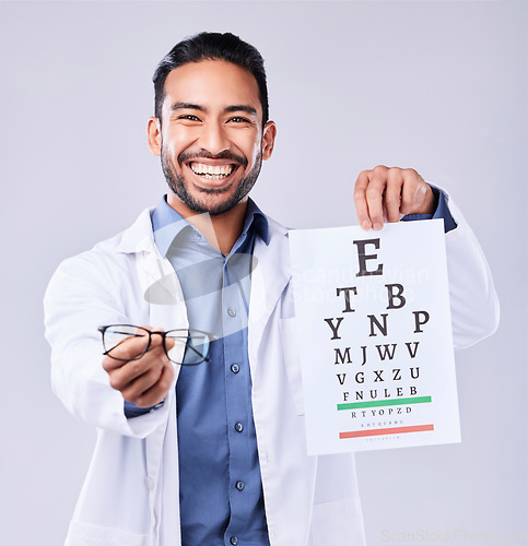 Image of Man, glasses and eye chart of ophthalmologist in portrait at studio isolated on white background. Face, spectacles and happy optometrist with snellen test document for vision, healthcare or wellness