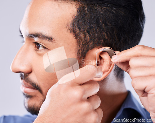 Image of Deaf, cochlear and asian man ear in studio with hearing aid, audio and implant installation. Audiology, sound waves and face of Japanese guy with a disability, vibration or communication device