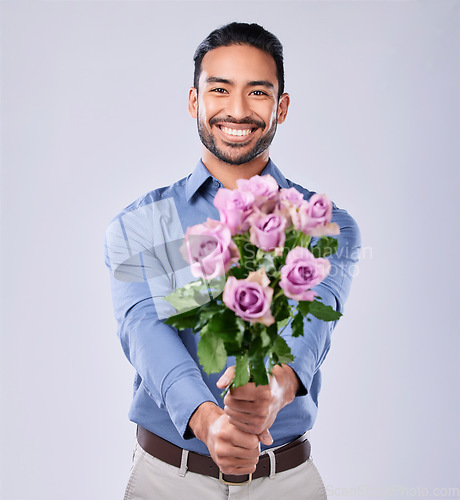 Image of Roses, portrait and happy man in studio with thank you, present or offer on grey background space. Face, flowers and Japanese male model with floral, bouquet or gesture of kindness, love or romance