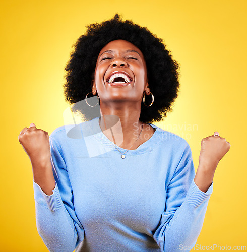 Image of Black woman, excited and fist in studio for success, celebrate freedom or winning lottery bonus on yellow background. Happy model, cheers or celebration of good news, crazy deal or lotto prize winner