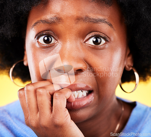 Image of Anxiety, biting nails and a woman scared in studio with fear, mental health or nervous behaviour. Face portrait of African person on yellow background worried, stress or panic for phobia or horror