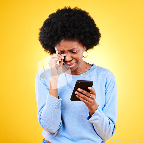 Image of Sad, fraud and woman with phone scam and identity theft problem and tech in studio. Stress, mobile error and confused from phishing, hacking and ecommerce spam with anxiety and yellow background