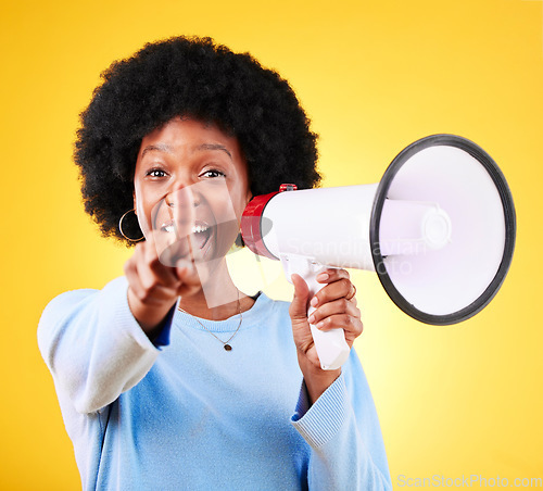 Image of Pointing, happy woman and loudspeaker or megaphone in studio for voice or announcement. African person portrait with speaker for broadcast message, breaking news or speech on yellow background