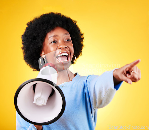 Image of Happy woman, loudspeaker or megaphone and pointing in studio for voice or announcement. African person with speaker for broadcast message, breaking news or speech communication on yellow background