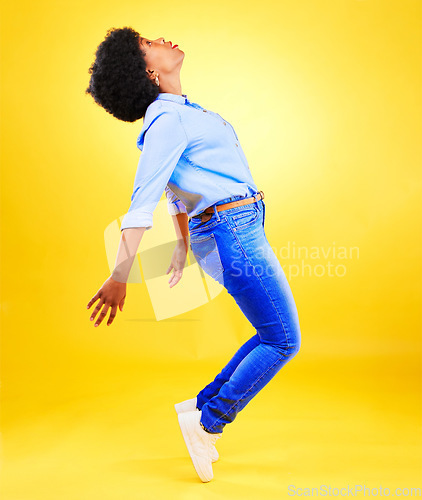 Image of Dance, balance and woman on tiptoe in studio with fun energy, positive attitude or action. Profile of African model person isolated on yellow background as freedom, belief and faith or casual fashion