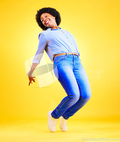 Image of Excited, happy and a woman tiptoe in studio with fun energy, positive attitude and action. Portrait of African model person isolated on yellow background for freedom dance, winner or celebration