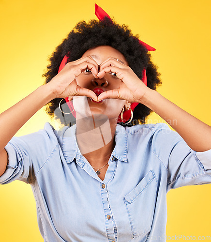 Image of Heart, sign and happy black woman with love hand gesture as support and care isolated in a studio yellow background. Kindness, emoji and young person with gratitude, like and review symbol or icon