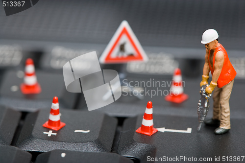 Image of Miniature figures working on a computer keyboard.