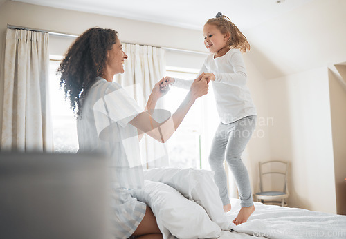 Image of Bed, mother and girl in a home, jump and family with love, weekend break and playing together. Parent, kid and child in a bedroom, fun and happiness with activity, morning and cheerful with energy