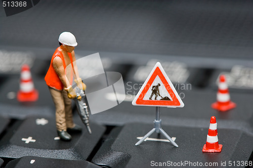 Image of Miniature figures working on a computer keyboard.