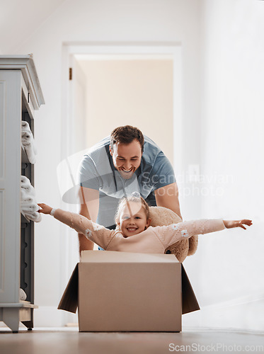 Image of Kid, father and pushing box in new house playing games or race with speed for bond, love or happiness. Dad, playful or excited child in cardboard with support, smile or trust on floor in family home