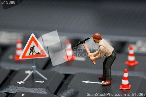 Image of Miniature figures working on a computer keyboard.