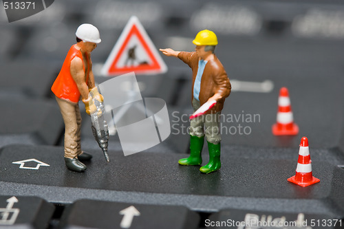 Image of Miniature figures working on a computer keyboard.
