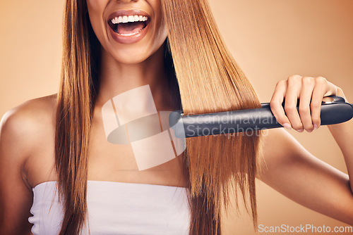 Image of Hand, hair straightener and woman in studio for beauty, cosmetics or appliance. Happy person on brown background for heat treatment, healthy results and hairdresser or salon flat iron on texture