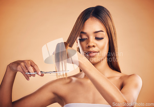 Image of Scissors, face and woman cut hair, split ends or doing hairstyle growth maintenance, self care routine or grooming treatment. Hairdressing product, beauty studio and model haircut on brown background