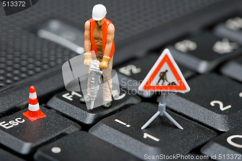 Image of Miniature figures working on a computer keyboard.