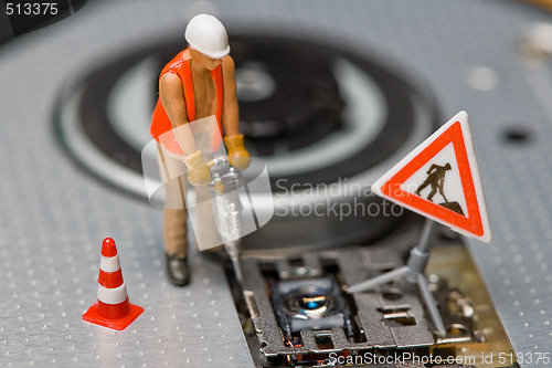 Image of Miniature figures working on a DVD drive.