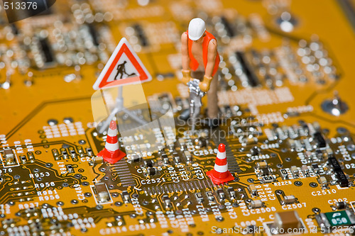 Image of Miniature figures working on a circuit board.