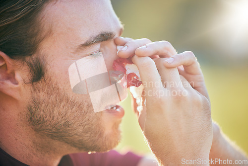 Image of Nose bleed, man and injury closeup on sport field with emergency, accident and blood outdoor. Swollen, broken and male athlete with medical and bruise after pain, game workout and exercise training