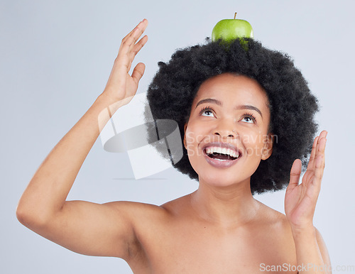 Image of Apple, balance and black woman with health, organic and diet for wellness and healthy in studio. Excited, smile and happy model with green fruit, skin nutrition and vegan food with grey background