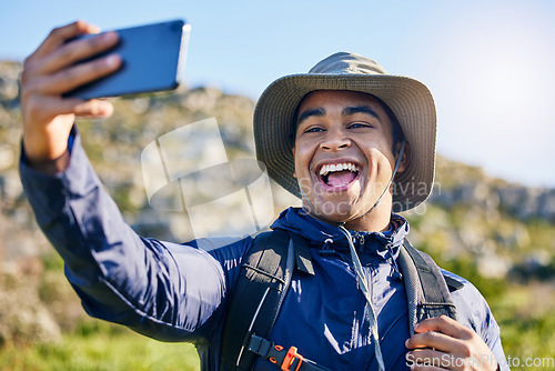 Image of Selfie, freedom and a man hiking in the mountains for travel, adventure or exploration in summer. Nature, smile and photography with a happy young hiker taking a profile picture outdoor in the sun