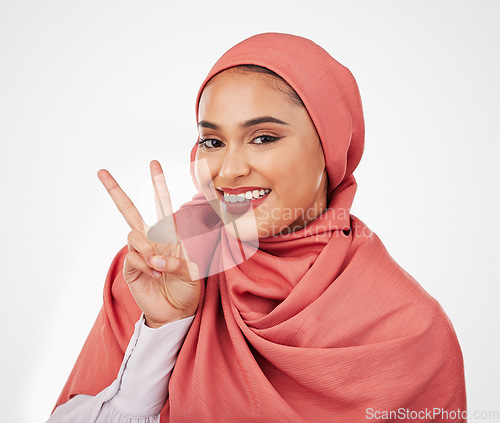 Image of Peace sign, smile and muslim with portrait of woman in studio for support, kindness and motivation. Happy, emoji and wellness with face of person on white background for excited and v hand gesture