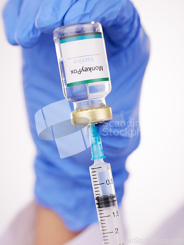 Image of Doctor, hands and syringe with monkeypox vaccine for cure, flu shot or vaccination at hospital. Closeup of medical person or healthcare worker extracting vial or antibiotic with needle for injection